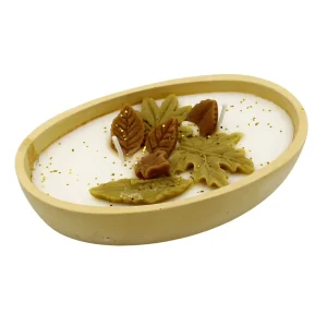 Ένα εντυπωσιακό οβάλ κερί, διακοσμημένο με περίτεχνα φύλλα σε ζεστές αποχρώσεις